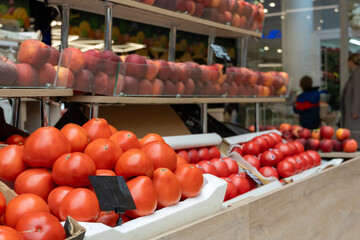 A vibrant display of fresh, ripe red tomatoes and nectarines