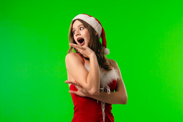 Surprised Woman in Santa Hat on Green Background