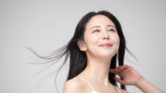 Portrait of a woman with long black hair blowing in the wind Beauty and hair care/treatment imagery Close-up video