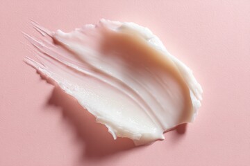 Macro photograph of moisturizing cream smear on pink surface, emphasizing smooth texture and hydration