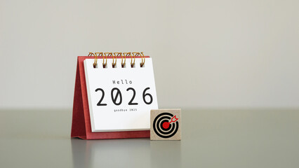 white desk calendar year 2026 with target icon on wooden cubes with copy space, symbolizing goals...