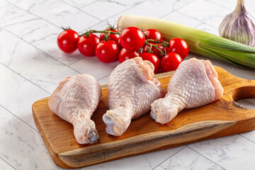 Fresh raw chicken drumsticks  over board