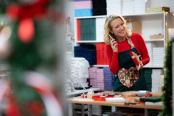 Woman handling christmas gift orders on phone