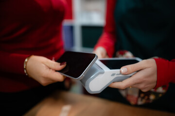 Customer making contactless mobile payment with phone at terminal