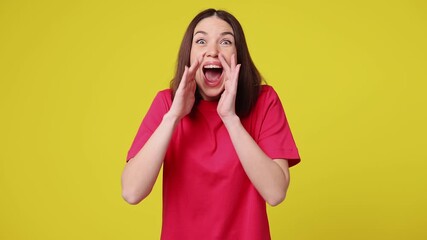 Excited happy fun young woman wear pink t-shirt casual clothes scream hot news about sales discount with hands near mouth hurry up isolated on plain yellow color background studio. Lifestyle concept