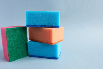 Colorful sponges for washing dishes on a blue background.