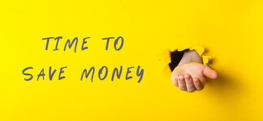 Hand emerging from yellow wall with message about saving money and financial awareness