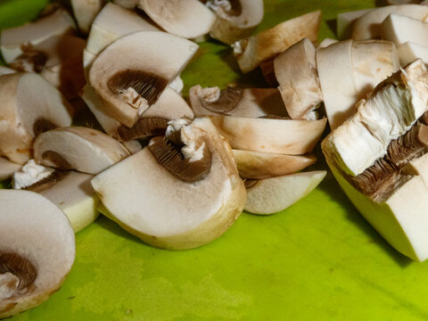 Raw Sliced Champignons on Bright Green Cutting Surface