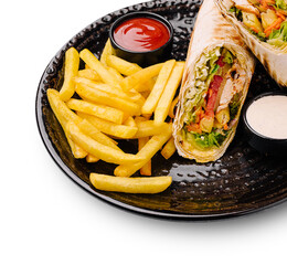 Tasty chicken wrap served with crispy fries and sauces at a casual eatery