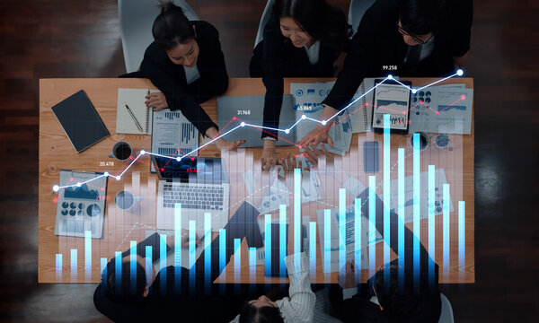 Professional business team engaged in data analysis, utilizing financial charts and technology during a strategic meeting in a modern office setting. Scalp - Powered by Adobe