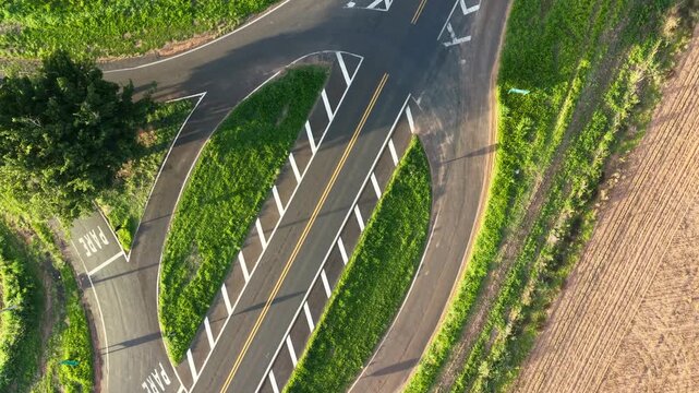 Aerial view of a roundabout with green grass and road markings visible