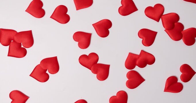 Small red hearts scattered across a white background, creating a festive and romantic atmosphere. Perfect for Valentine's Day projects and expressing love.