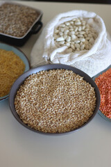 Bowls and bags full of various healthy grains and legumes. Selective focus.