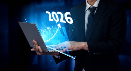 A business professional analyzes future data trends on a laptop, visualizing growth projections for 2026 in a dynamic digital environment, showcasing innovation and strategy. Tessel