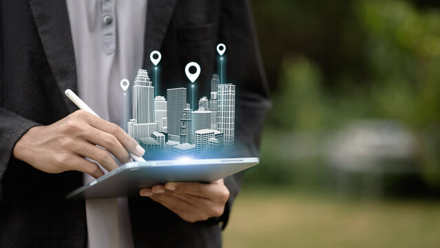 Business person using digital tablet with holographic smart city buildings and location pins. - Powered by Adobe