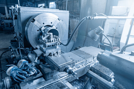 old metalworking machine. Vintage lathe in the production hall in blue tones
