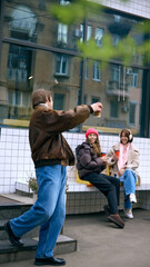 Friends talking outside cafe in winter street scene. Concept of coffee shops, urban tourism, social...