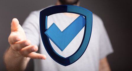 Image of a man holding a digital shield with a checkmark, emphasizing security, data protection and concepts of reliability, trust an