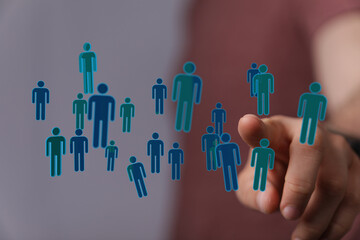 Hand pointing at floating digital people representing community, networking, social media, and digital connecti