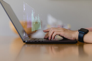 hands typing on a laptop with virtual analytics chart overlay, representing business data analysis,...