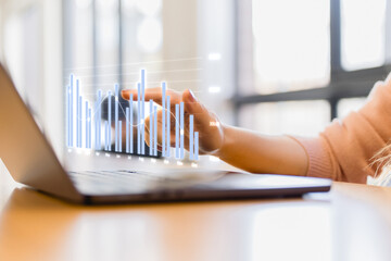 hands typing on a laptop with virtual analytics chart overlay, representing business data analysis, digital marketing insights financial performance tracking.