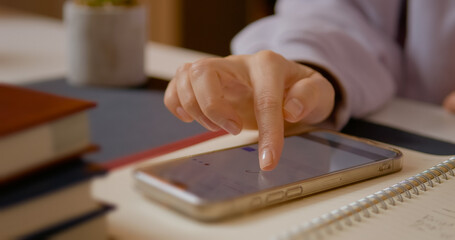 Woman is attempting to digitally sign using her smartphone, making several attempts to write her signature clearly on the screen in a home office environment.