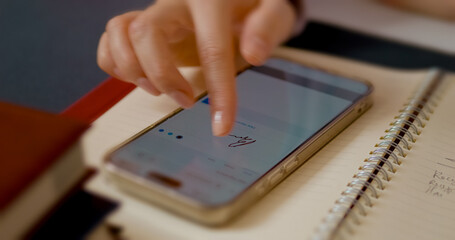 Professional businesswoman efficiently signing digital document using smartphone, placed on notebook with focused precision, representing modern business technology and paperless workflow