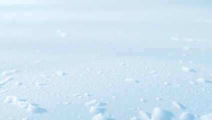 Snowy landscape with small snow chunks on the ground and blue sky