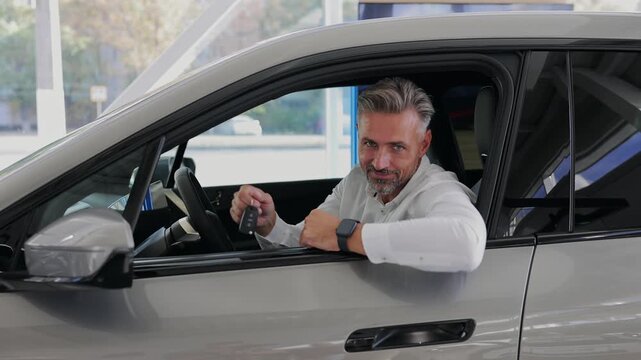 Man customer male buyer client wears white show keys fob keyless system shirt chooses auto wants to buy new automobile in car showroom vehicle salon dealership store motor show indoor. Sales concept