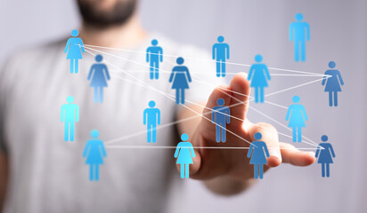 Concept of global connection, networking and communication between people, using virtual icons. Shows human hand touching network of digital fig