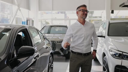 Man customer male buyer client wearing white show keys fob keyless system shirt chooses auto wants to buy new automobile in car showroom vehicle salon dealership store motor show indoor. Sales concept