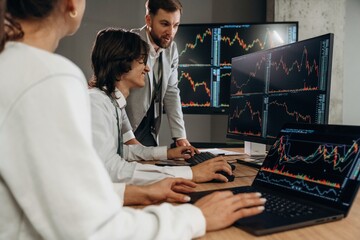 Side view, man is giving advises. Business people are working with stock market exchange in office