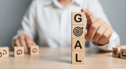 Setting Business Goals and Achieving Success Concept with Hand Stacking Wooden Blocks Labeled 'GOAL' and Target Icon
