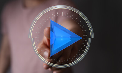 Close-up of a hand interacting with a glowing play button integrated within a clock design, symbolizing concepts like time, video, an