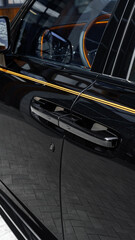 Close-up of a sleek black car door with a modern handle and reflective surface details