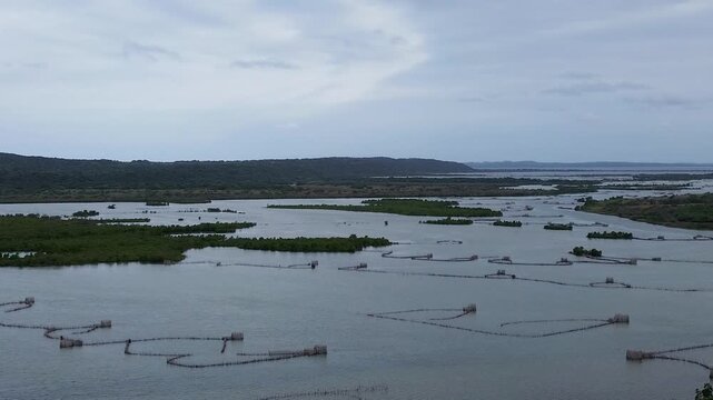 Kosi Bay Mouth with Traditional Thonga or Tsonga Fish Traps, camera panning down from a cloudy sky to show the fish traps in the lakes. 4K Aerial Video.