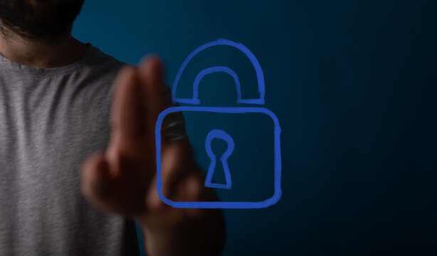A man's hand interacts with a glowing blue digital padlock icon, symbolizing advanced cybersecurity, data protection, and privacy in a modern te