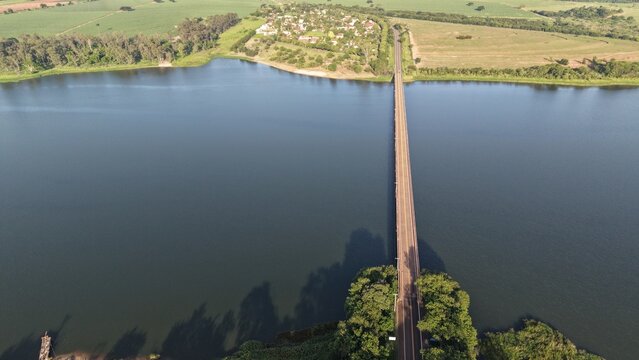 Aerial view of a long road stretching across a body of water outdoors