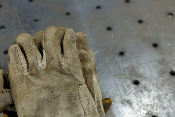 Work gloves resting on a metal surface after a long day of labor in a workshop