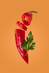 Romero pepper and parsley leaf on orange background, food levitation