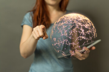 A woman points towards a glowing digital network sphere, symbolizing innovation, connection and global technology. Perfect for digital transform