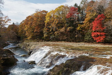 River flowing over waterfall in Japanese autumn countryside, Otaki Falls, Hokkaido