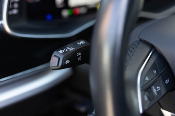 Headlight adjustment knob in the car. Turn signal switch, headlight fog lamp dimmer control switch, multifunction switch in modern car, shallow depth of field. The switch of light of headlights