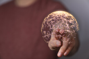 Digitally rendered glowing sphere with network connections, representing global connectivity and modern technology. Hand gestures showing intera