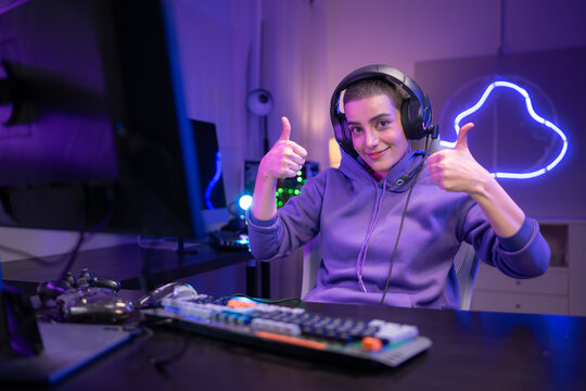 A focused gamer sits at a desk and types on a mechanical keyboard in a neon-lit gaming setup