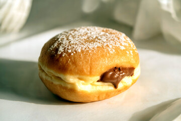 Cream Filled Donut with Chocolate Center and Powdered Sugar on Light Background