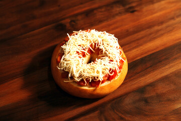 Cheese Topped Savory Donut with Tomato Filling on Wooden Surface