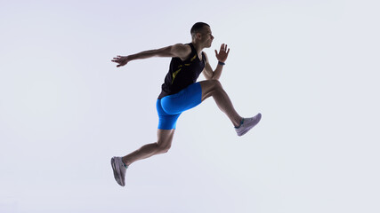 Naklejka premium Athlete jumping forward in extended mid-stride. Concept of stride-length drills, mid-air control training, power-stride technique lessons, athlete development modules.