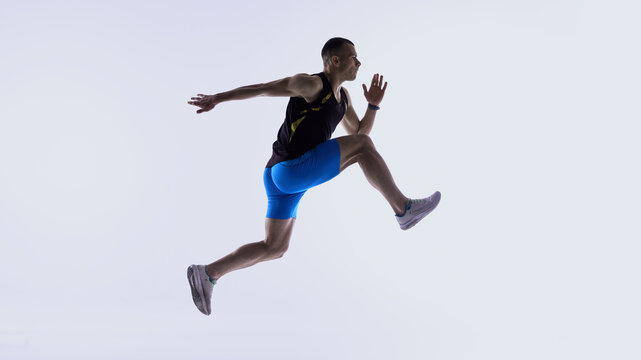 Athlete jumping forward in extended mid-stride. Concept of stride-length drills, mid-air control training, power-stride technique lessons, athlete development modules.