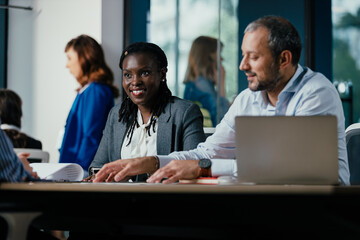Smiling Black Woman Leading Feedback Session Meeting in Modern Open Office